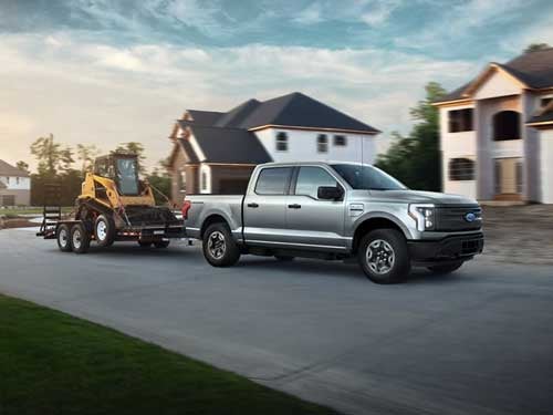 2023 Ford F-150 Lightning towing a tractor