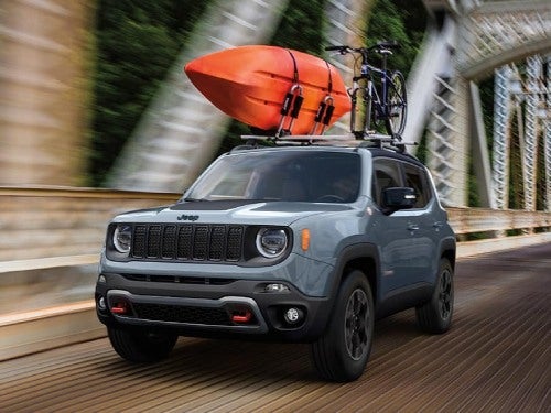 2023 Jeep Renegade driving on the road hauling a kayak