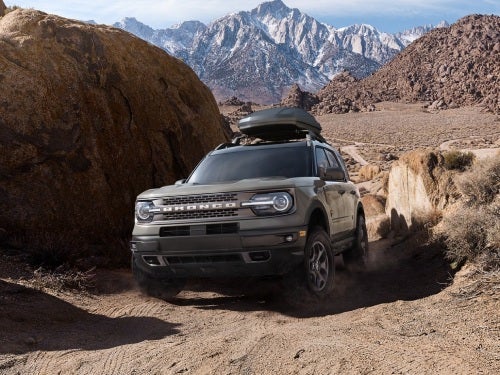 2024 Ford Bronco Sportv off-roading up a rocky path with mountains in the background 