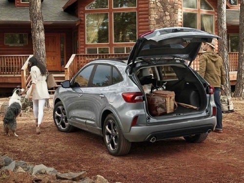 2024 Ford Escape Plug-in Hybrid parked at a cabin with back door open and cargo full of bags