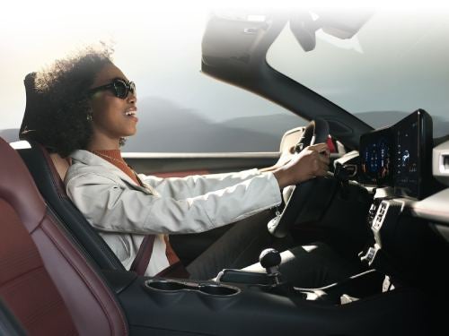 2024 Ford Mustang interior view of woman driving with top of vehicle off