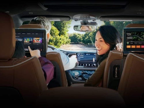 2024 Chrysler Pacifica view of mom in front seat looking back at child in back seat using rear seat entertainment system