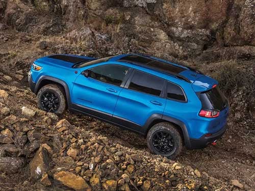 2023 Jeep Cherokee driving up a rocky hill