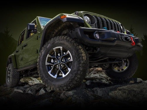 2024 Jeep Wrangler close up exterior view looking up at front of vehicle parked on rocky terrain
