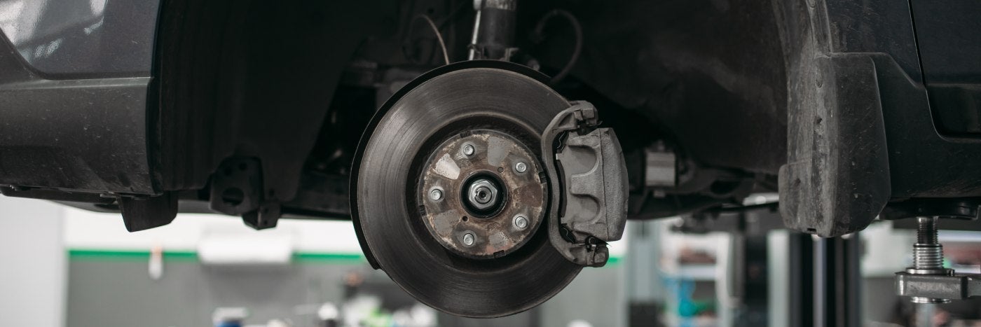 View of vehicle with removed wheel on a lift brake disc